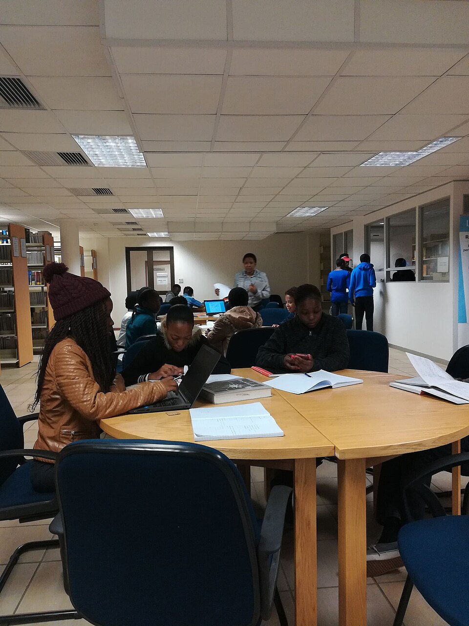 Students using books in a modern university library