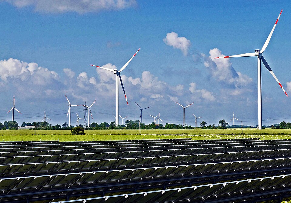 Solar panels, wind turbines, and an electricity pylon; unidentified location
